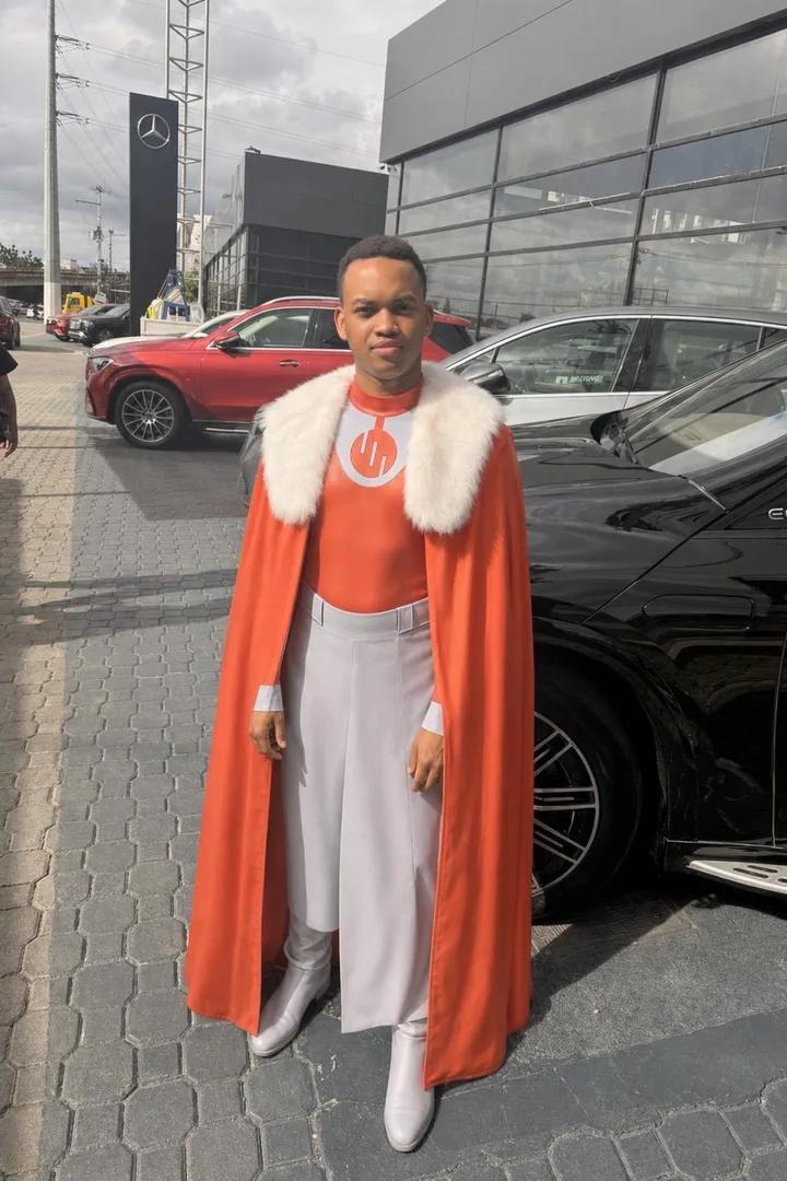 Virtual outfit preview with a red cape, white fur collar, and pale trousers